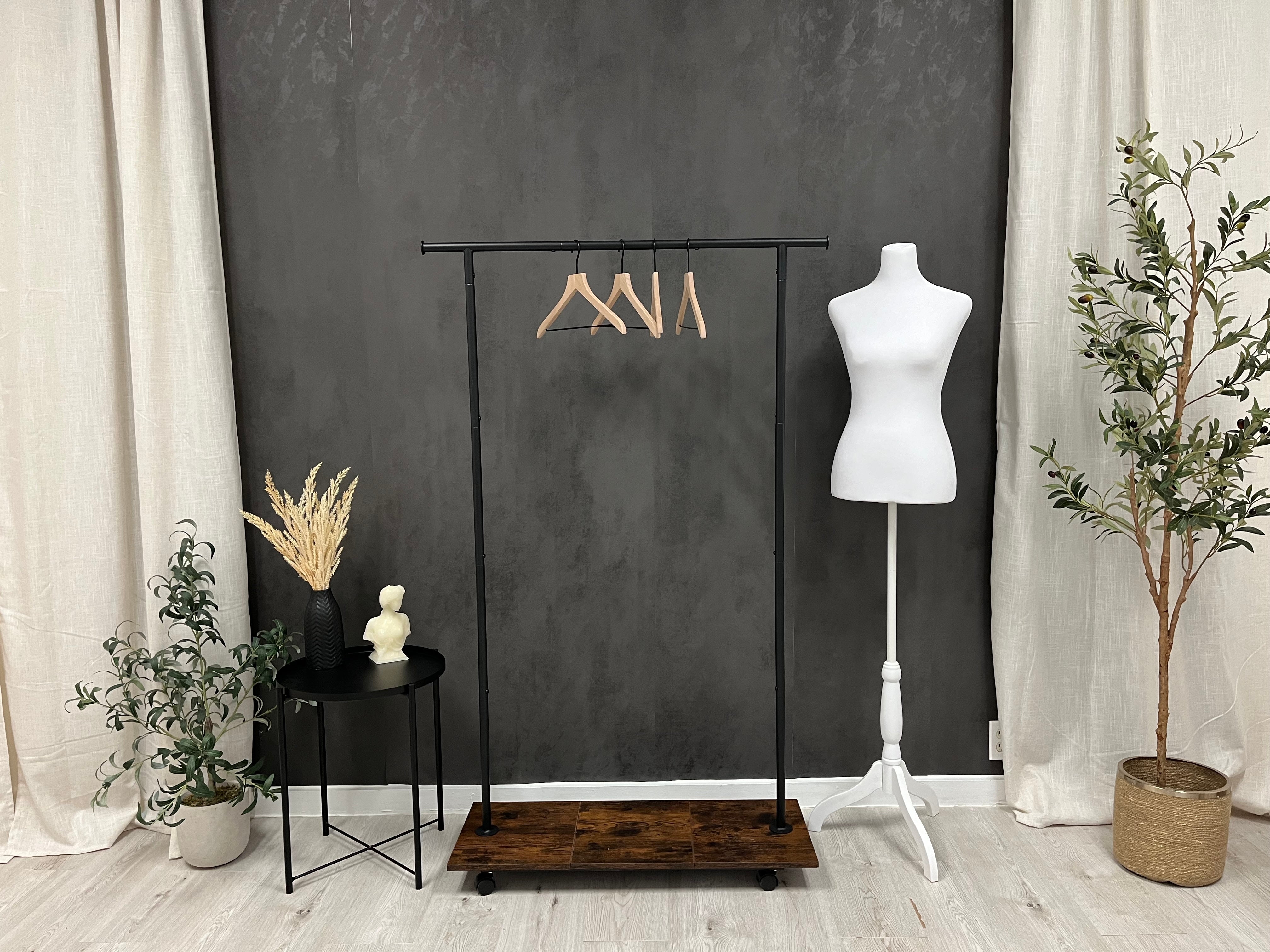 A studio setting with an empty clothing rack.